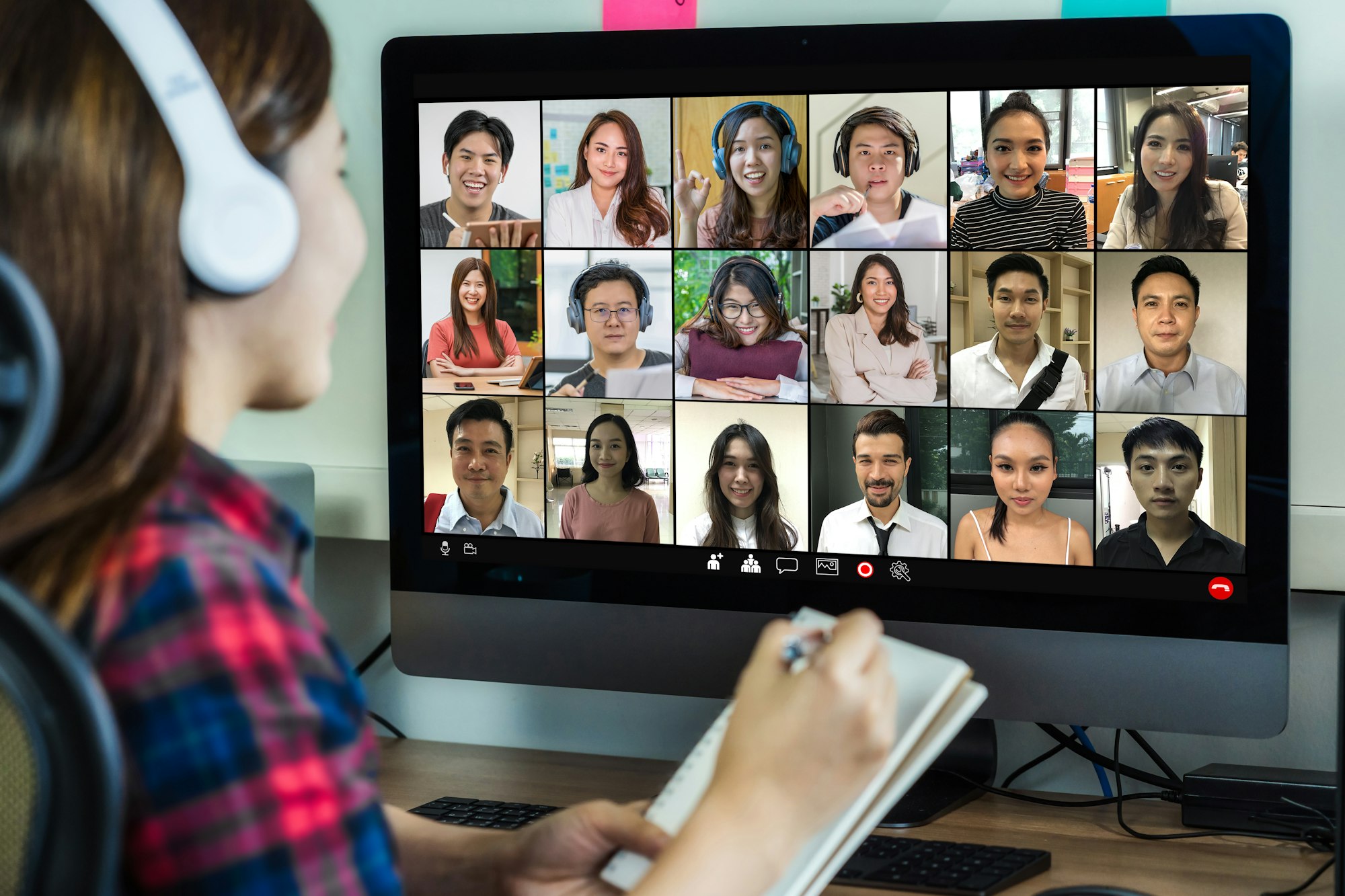 Rear view of Asian businesswoman working and online meeting via video conference with colleague